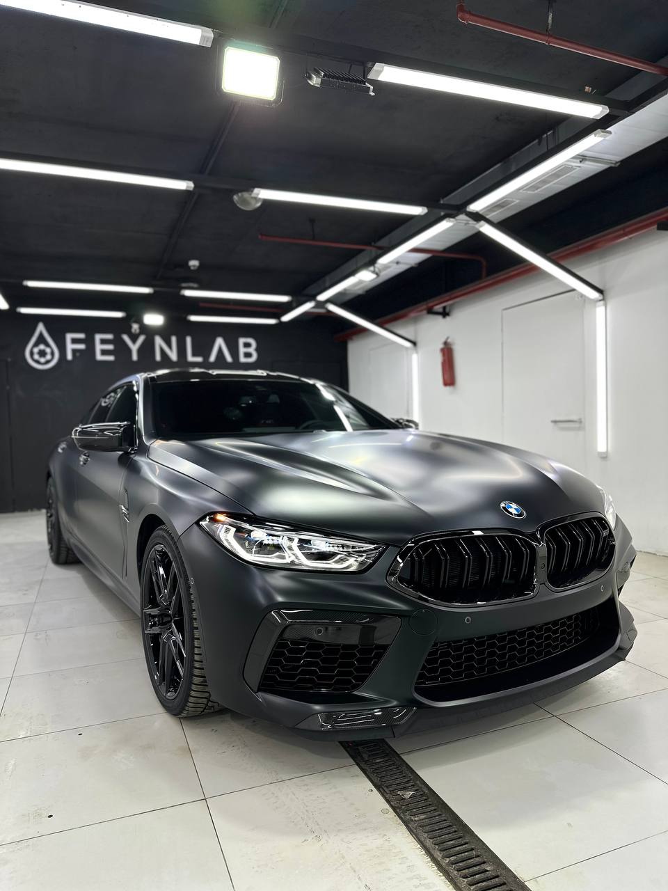 Черная BMW M8 на оклейке пленкой в FEYNLAB вид спереди фото